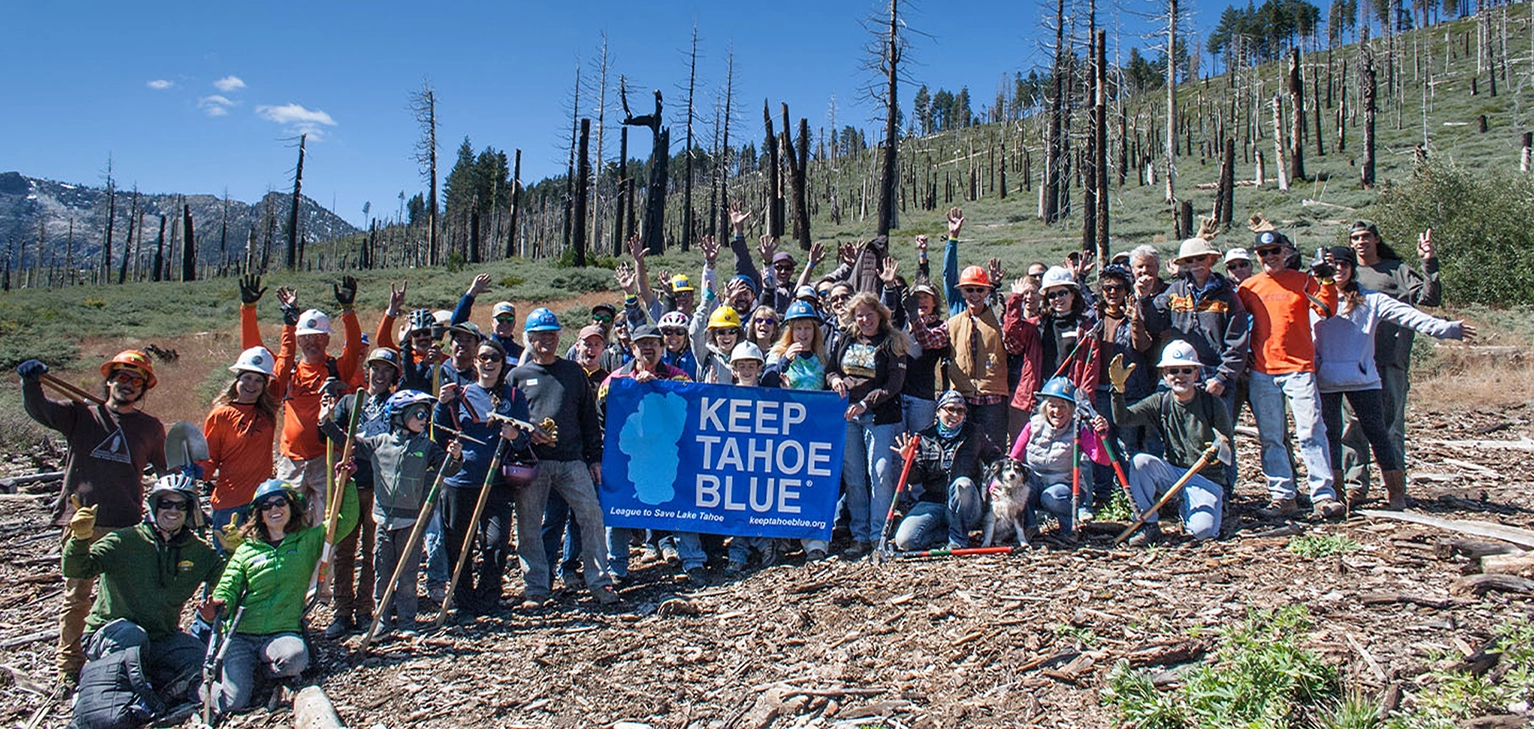 Photo of Keep Tahoe Blue members with a banner standing on a hillside